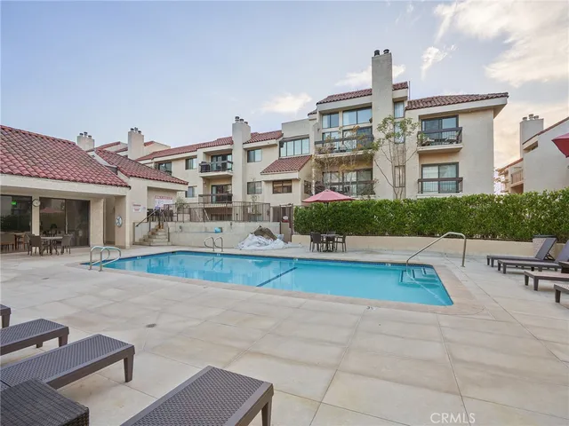 a swimming pool with outdoor seating and yard in the back