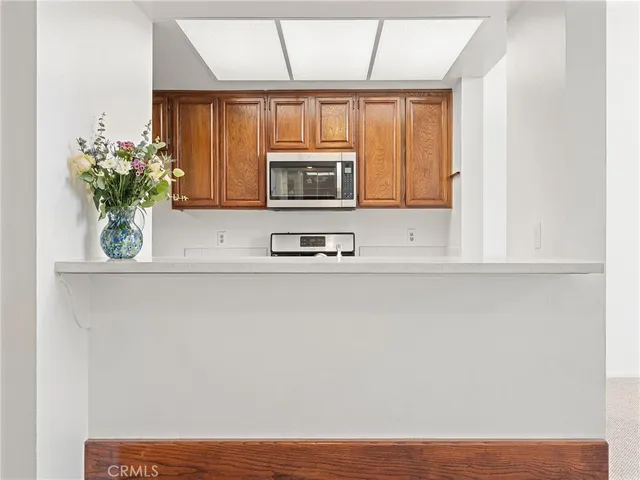 a kitchen with a microwave cabinets and a window