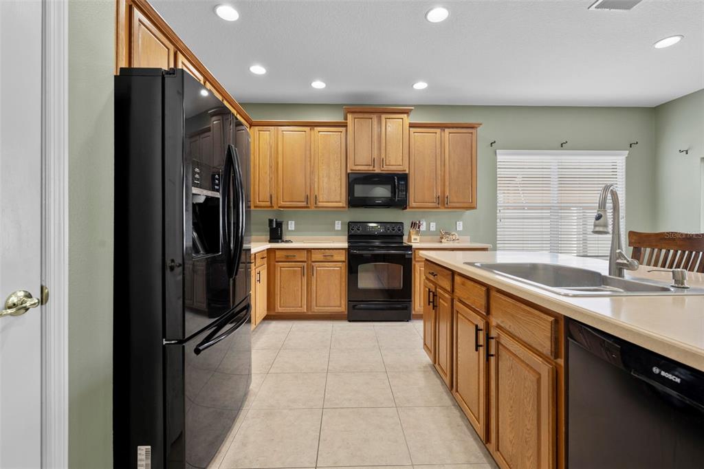 632 Winthrop Drive Spring Hill, FL 34609 - Photo 13 of 49 a large kitchen with stainless steel appliances granite countertop a stove a sink and a refrigerator