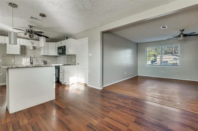 a view of a house with a big yard and large trees