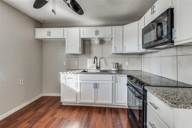 a kitchen with stainless steel appliances granite countertop a sink stove and microwave