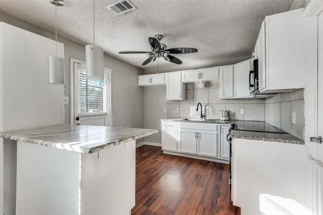 a kitchen with a sink window a refrigerator and cabinets