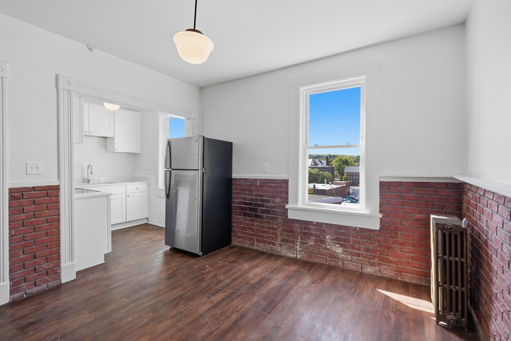 105 High Street, Unit 4P Holyoke, MA 01040 - Photo 2 of 11 a view of a kitchen with a refrigerator a stove top oven and cabinets