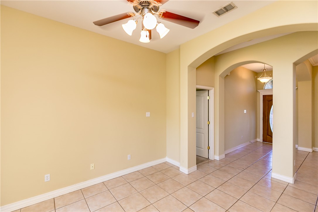8209 Tango Circle Corpus Christi, TX 78414 - Photo 18 of 28 an empty room with a chandelier fan and glass door