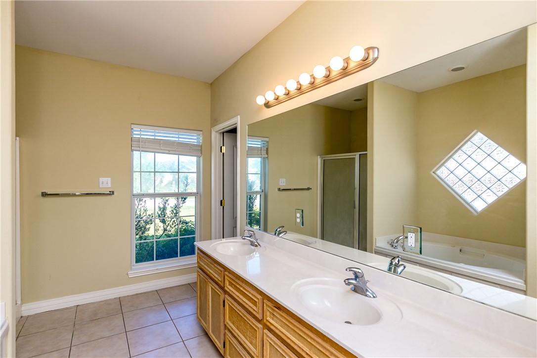 8209 Tango Circle Corpus Christi, TX 78414 - Photo 20 of 28 a bathroom with a sink a large mirror and a bathtub