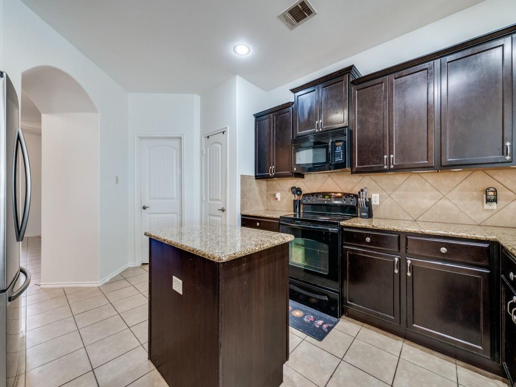 2313 Luscombe Lane Anna, TX 75409 - Photo 10 of 30 a kitchen with stainless steel appliances granite countertop wooden cabinets a stove top oven a sink and dishwasher