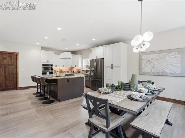 a kitchen with a dining table chairs sink and refrigerator