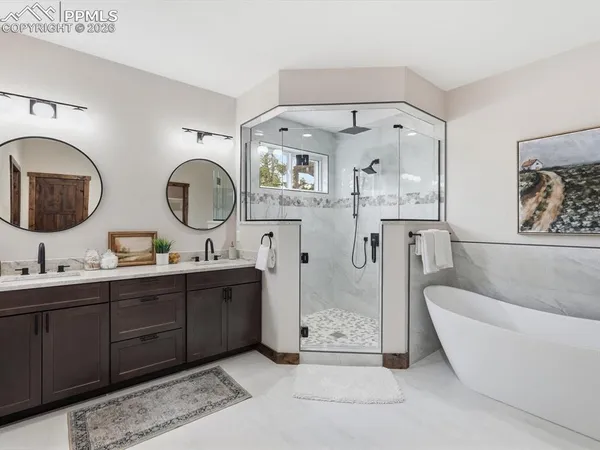 a spacious bathroom with a double vanity sink mirror and bathtub