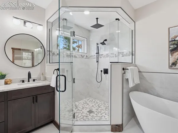 a bathroom with a double vanity sink mirror and bathtub