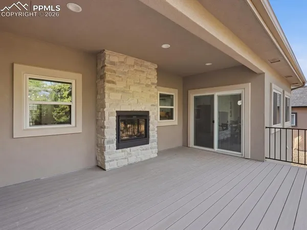 an empty room with wooden floor a fireplace and windows