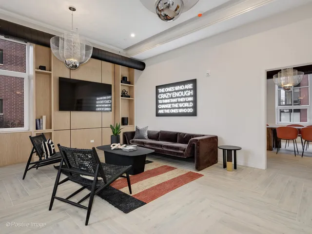 a living room with furniture a flat screen tv and kitchen view