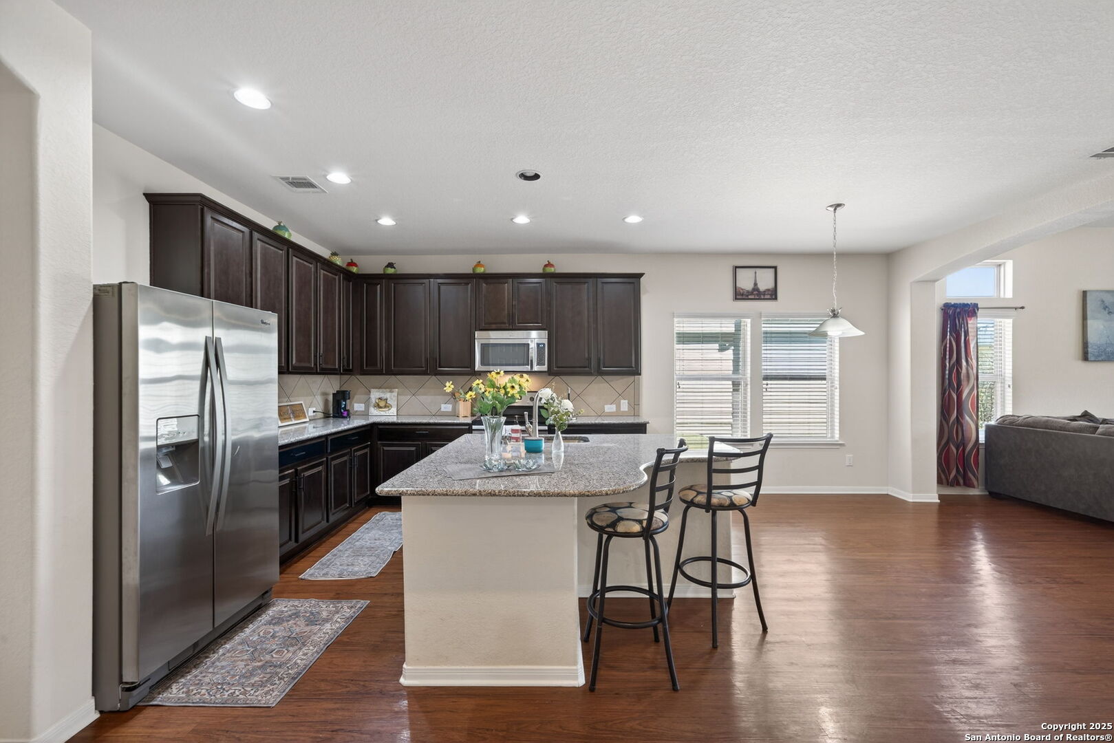 147 Brook View Cibolo, TX 78108 - Photo 12 of 29 a kitchen with stainless steel appliances kitchen island granite countertop a refrigerator a stove a sink a dining table and chairs with wooden floor