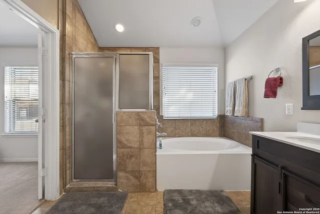a bathroom with a bathtub sink vanity and mirror