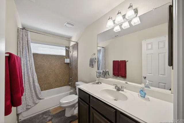 a bathroom with a sink a toilet a mirror and shower