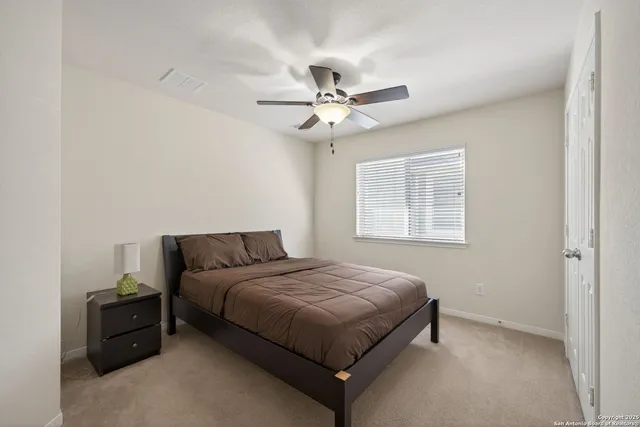 a bedroom with a bed and a ceiling fan