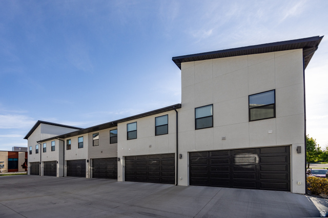 220 Spring Creek Parkway Providence, UT 84332 - Photo 11 of 17 Modern multi-level townhome exteriors featuring varied siding textures, black-framed windows, and integrated garage access