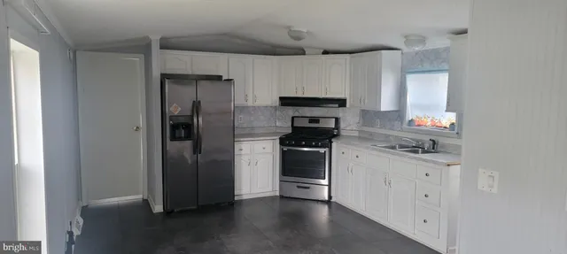 a kitchen with a refrigerator sink and stainless steel appliances