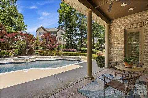 a view of a swimming pool with a bench and trees in the background