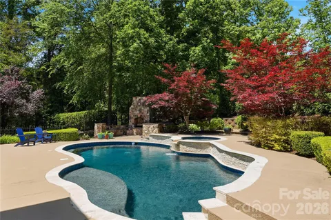 a view of a swimming pool with lawn chairs and a fire pit