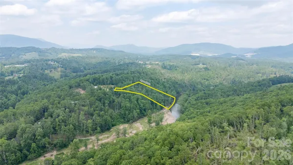 a view of a green field with mountains in the background