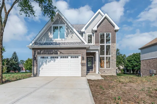 a front view of a house with a garden and plants