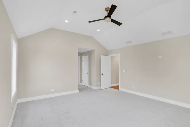 an empty room with a ceiling fan and window