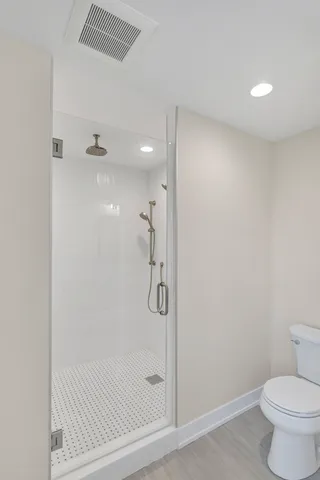 a bathroom with a granite countertop bathtub shower and toilet