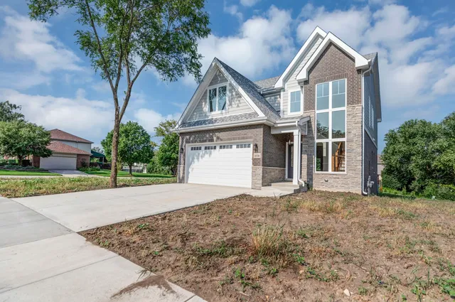 front view of a house with a yard and an trees