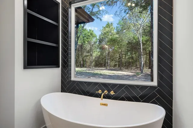 a white bath tub sitting in a bathroom next to a window