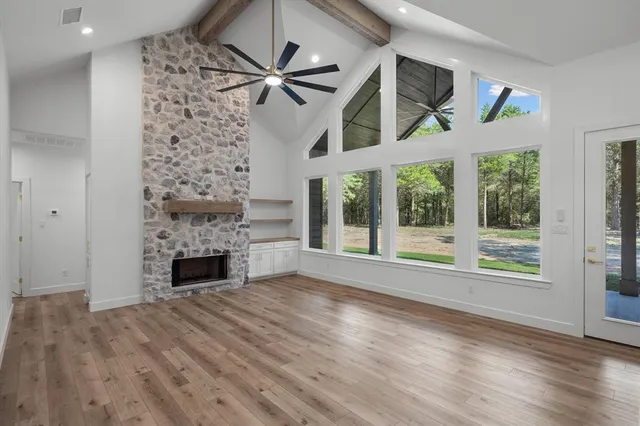 a view of an empty room with a fireplace and a window
