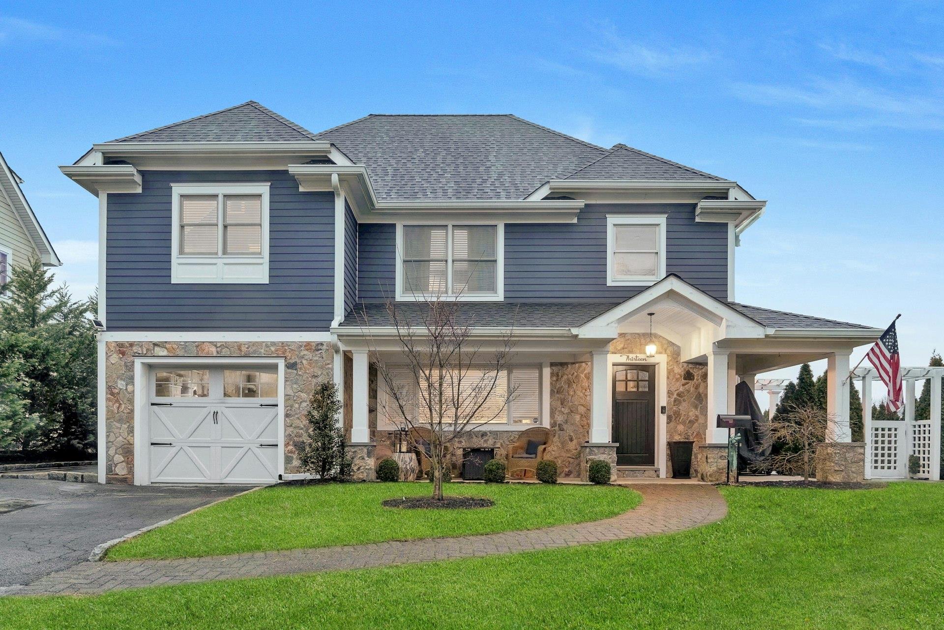 Welcome to 13 Joyce Rd; Craftsmanship throughout with a view of the garage, front yard, and covered porch
