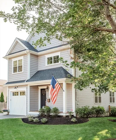 a front view of a house with a yard and trees