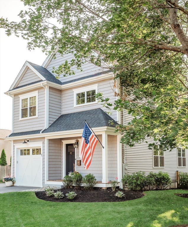a front view of a house with a yard and trees