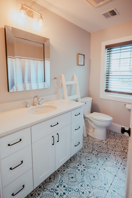 1 Proctor Street Natick, MA 01760 - Photo 17 of 23 a bathroom with a granite countertop toilet sink and mirror