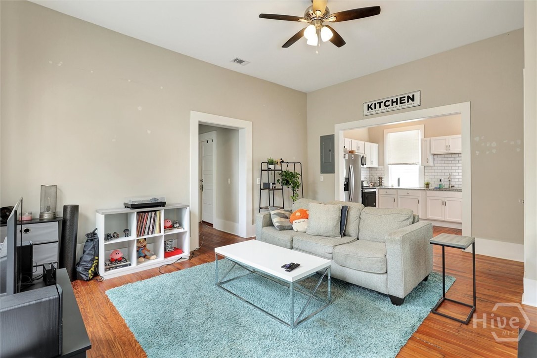 309 West 33rd Street Savannah, GA 31401 - Photo 21 of 35 Bright living room with hardwood floors, high ceilings, and easy flow into the kitchen.