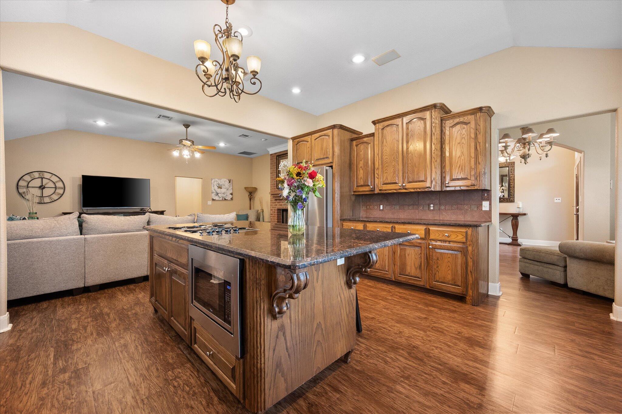 5908 110th Street Lubbock, TX 79424 - Photo 13 of 31 a living room with stainless steel appliances kitchen island granite countertop a stove and a refrigerator