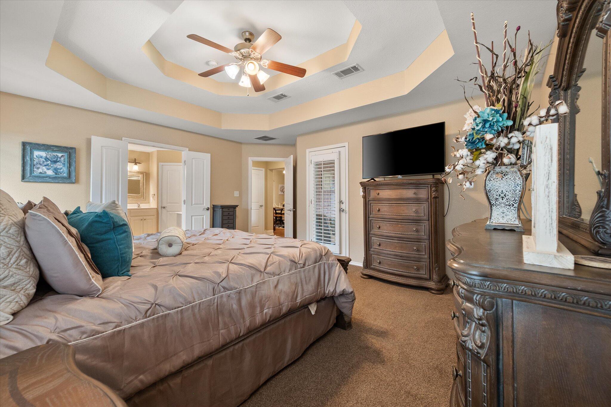 5908 110th Street Lubbock, TX 79424 - Photo 21 of 31 a spacious bedroom with a bed and a flat screen television