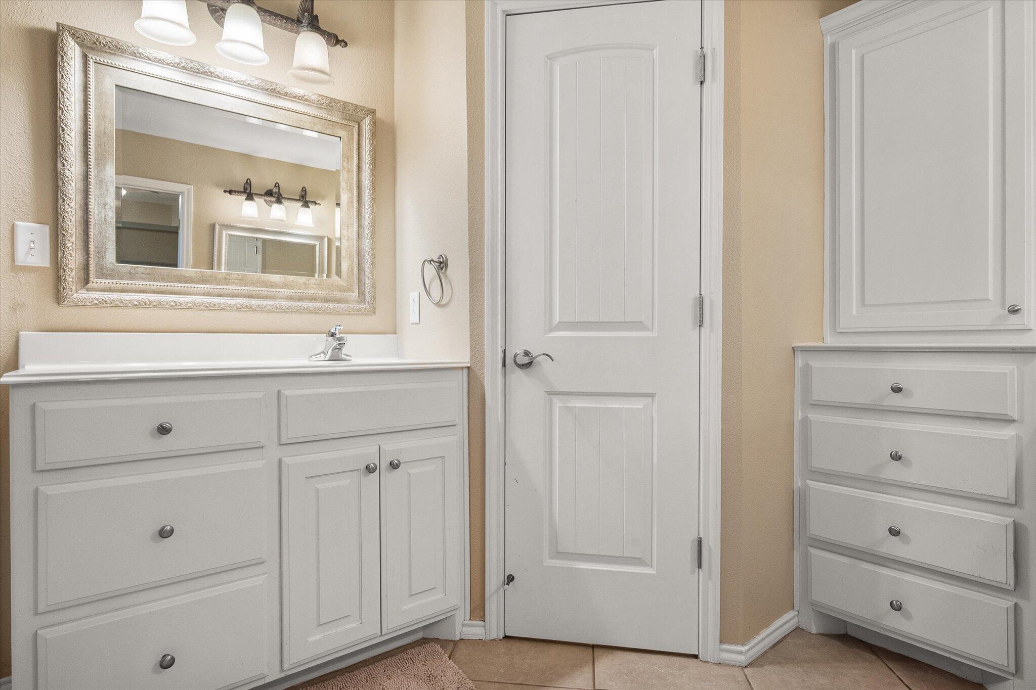 5908 110th Street Lubbock, TX 79424 - Photo 22 of 31 a bathroom with a sink vanity and mirror