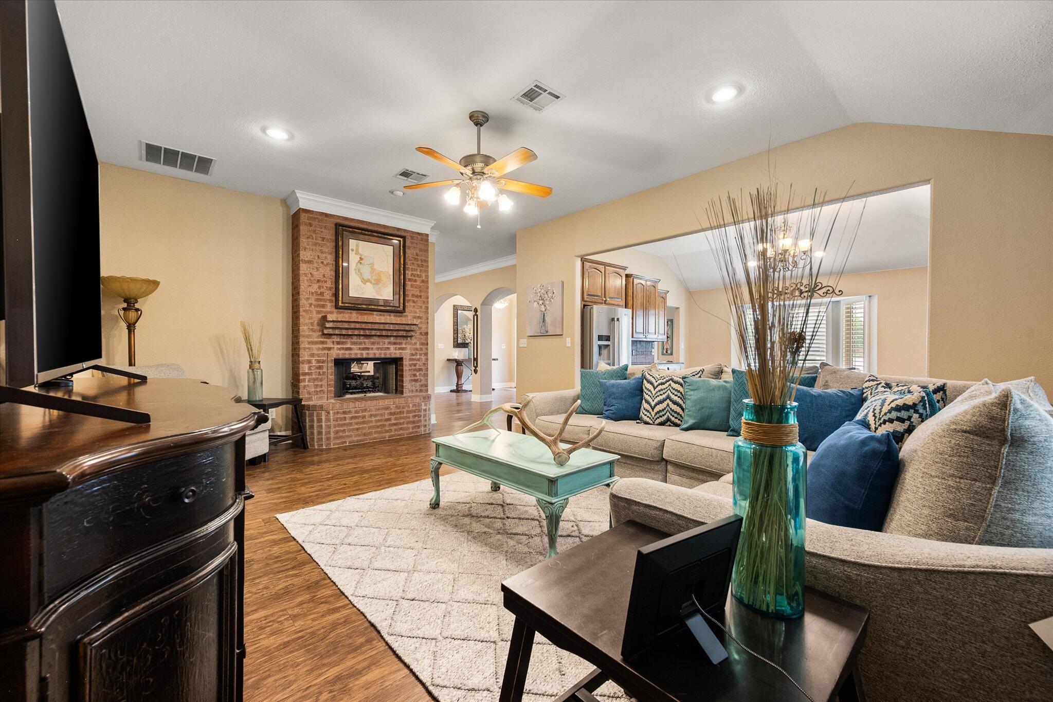 5908 110th Street Lubbock, TX 79424 - Photo 9 of 31 a living room with furniture a fireplace and a flat screen tv