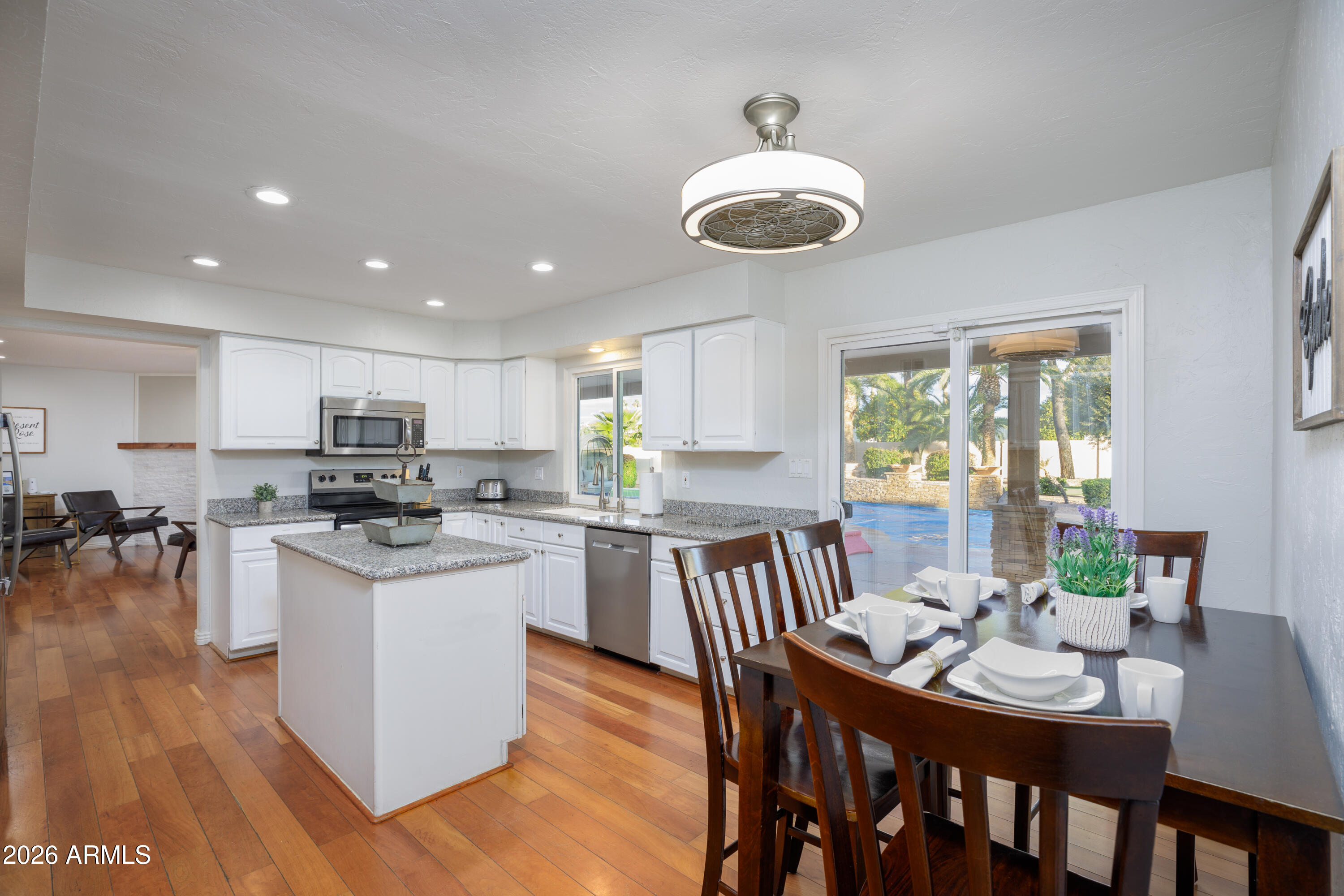 6932 East Presidio Road Scottsdale, AZ 85254 - Photo 15 of 30 a kitchen with stainless steel appliances granite countertop a stove a refrigerator a kitchen island a dining table and chairs