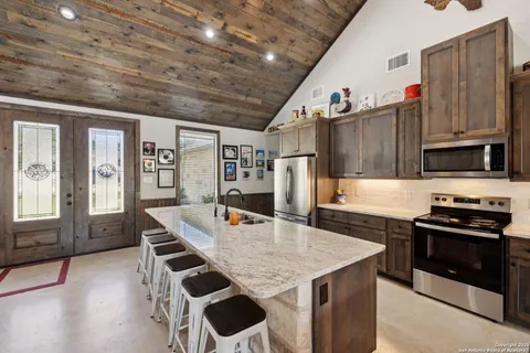 a kitchen with stainless steel appliances granite countertop a stove a refrigerator and a microwave