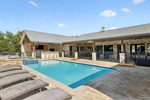 a view of a house with swimming pool and sitting area