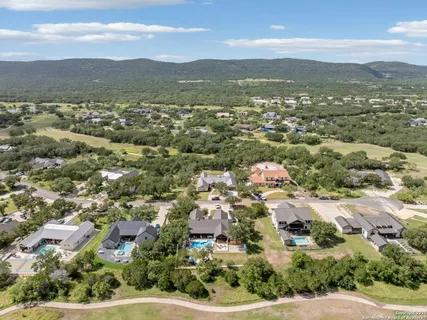 an aerial view of residential houses with outdoor space and trees