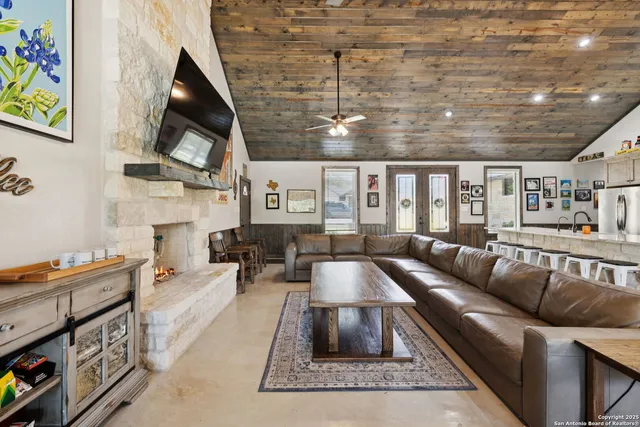 a living room with furniture a flat screen tv and a fireplace