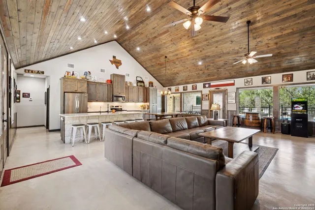 a living room with couches and kitchen view