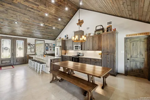 a living room with furniture a rug and kitchen view
