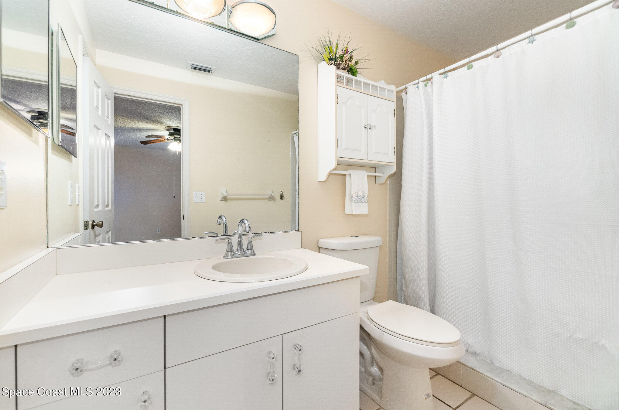 2399 Angel Road Palm Bay, FL 32909 - Photo 14 of 26 a bathroom with a sink a toilet a mirror and shower