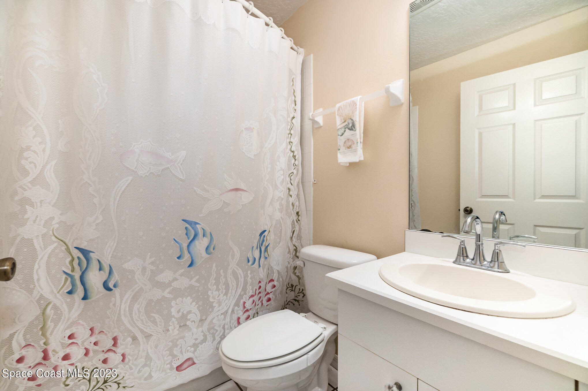 2399 Angel Road Palm Bay, FL 32909 - Photo 16 of 26 a bathroom with a sink a toilet and shower curtain