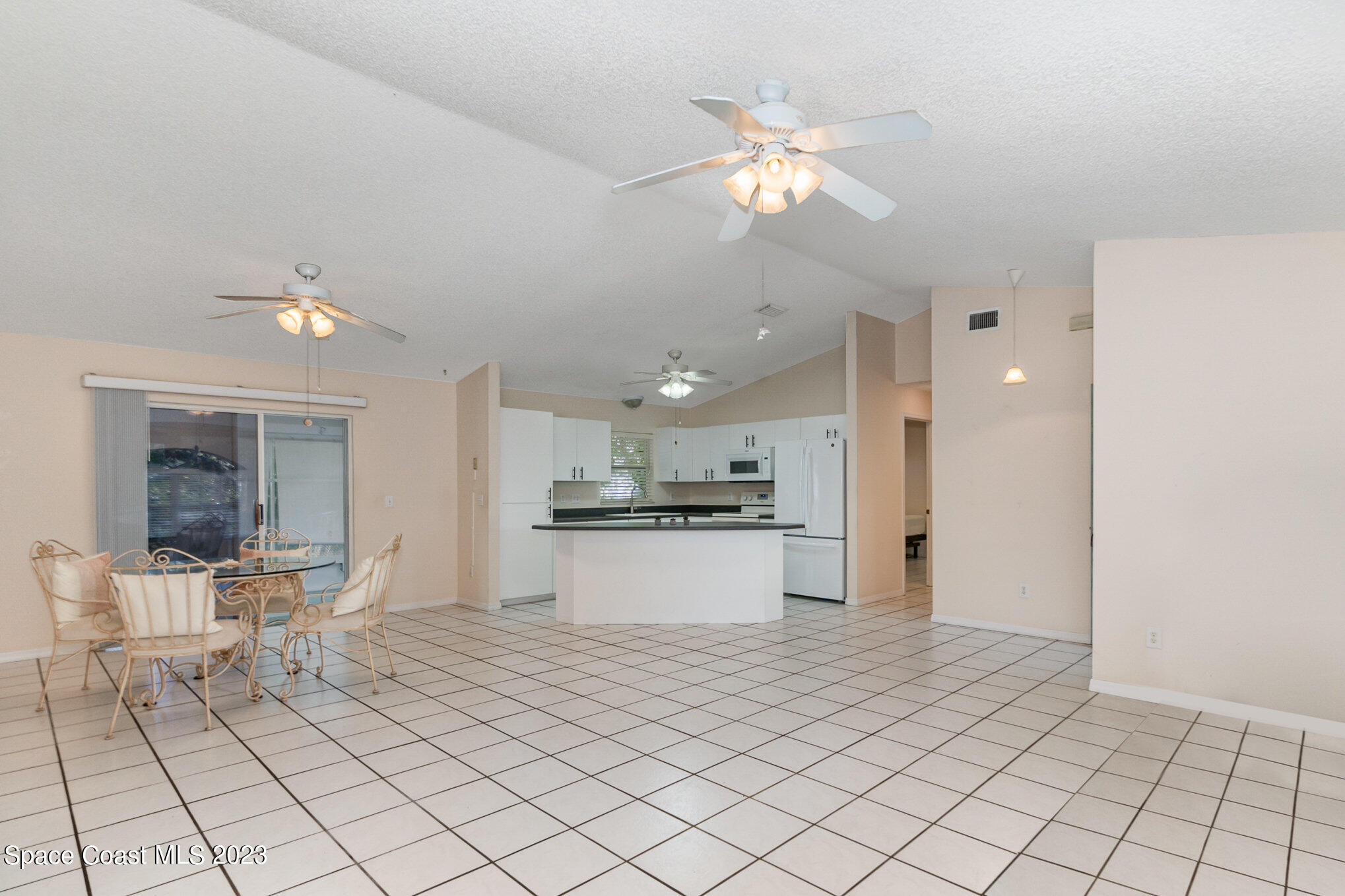 2399 Angel Road Palm Bay, FL 32909 - Photo 4 of 26 a large white kitchen with a sink and chandelier