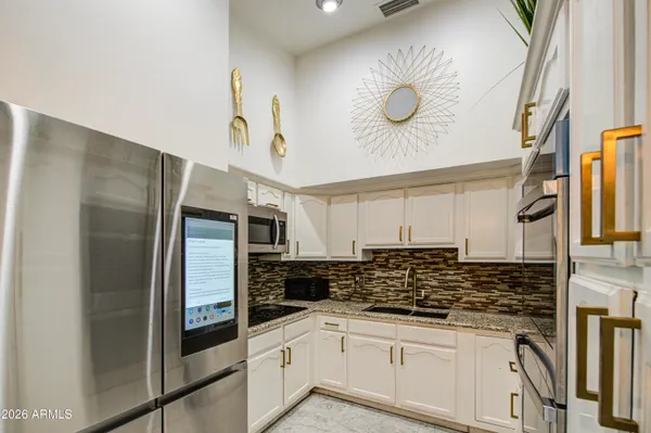 a kitchen with stainless steel appliances granite countertop a sink and cabinets